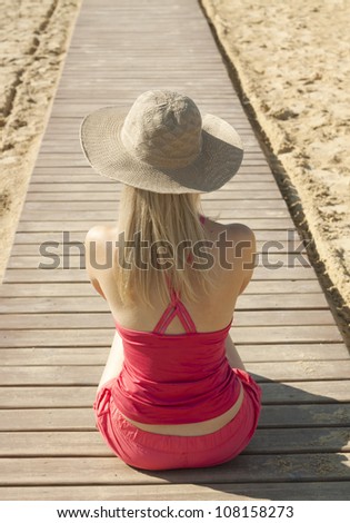 girl sitting back on track by the sea
