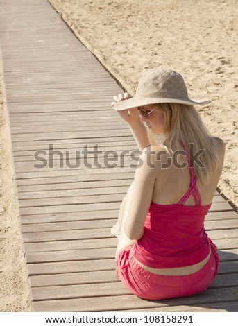 girl sitting back on track by the sea