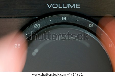hands turning up the volume on a stereo
