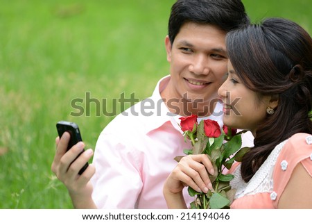 Young couple man and woman looking mobile phone and smiling