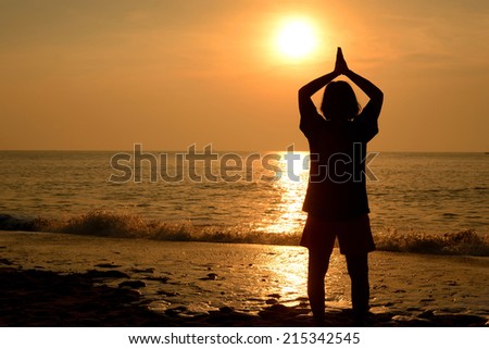 Silhouette woman Yoga at the beach