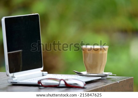 Hot coffee cup and with laptop on wood table