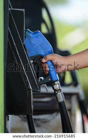Petrol gas station pump and pumping gasoline fuel with hand