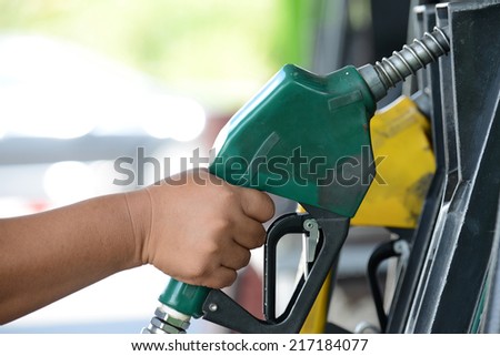 Petrol gas station pump and pumping gasoline fuel with hand