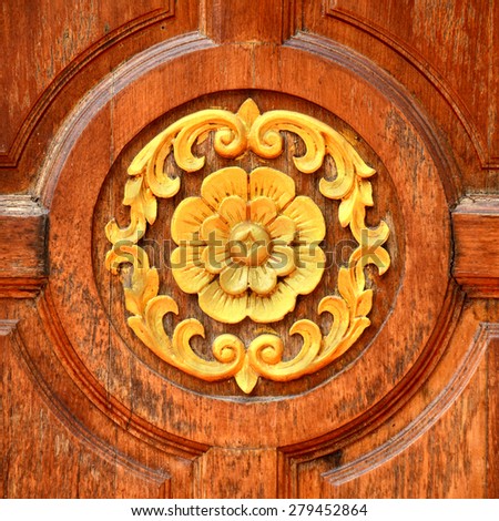 Teak wood carve and gold painting Thailand style at the temple door