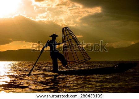 Silhouette fishermen (unrecognizable people) on boat and net at Inle Lake, Myanmar