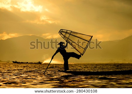 Silhouette fishermen (unrecognizable people) on boat and net at Inle Lake, Myanmar