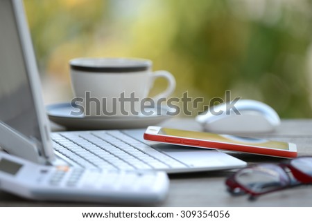 Coffee cup smartphone and laptop computer on business wooden table