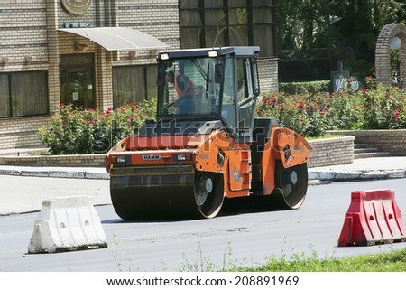 Kharkiv - JULY, 27 2014: team of builders puts asphalt on the street according to the city plan Klochkivska overhaul of the roads in 2014