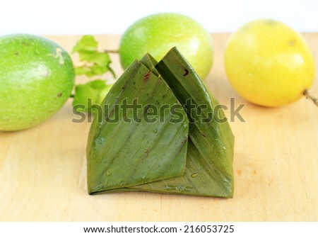 Thai traditional sticky rice dessert in banana leaf packaging.Bananas with Sticky Rice.
