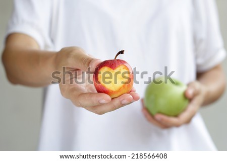 Women hand holding apple with heart shape. Sharing concept.