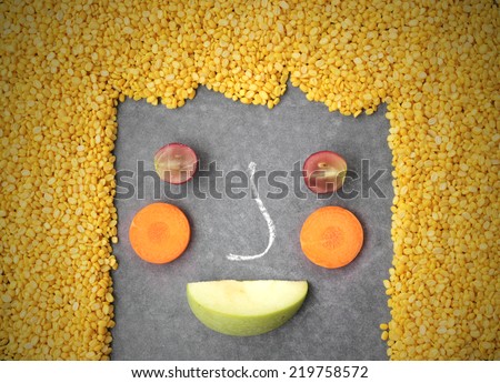 Happy fruit, bean and vegetables face on black background.