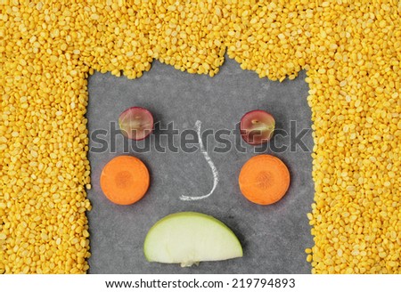 Unhappy vegetables face on black background.
