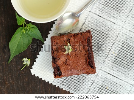 Brownie cake with hot tea put on wooden table for time break.