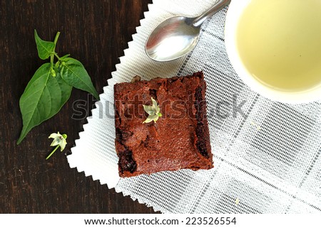 Brownie cake with hot tea put on wooden table for time break.