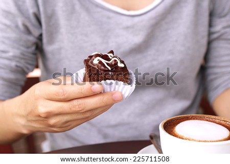 Women hand holding brownie cake.
