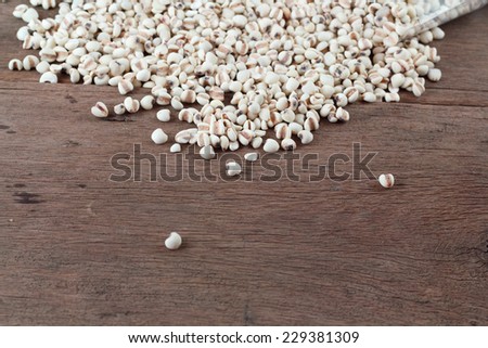 Millet the organic grain food in plastic back on wood table.