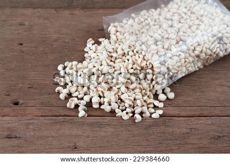 Millet the organic grain food in plastic bag on wood table.