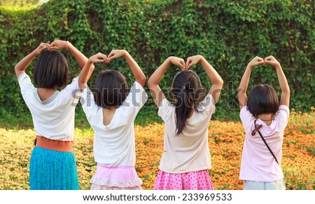 lovely girls use hand cover and touch to make heart sign