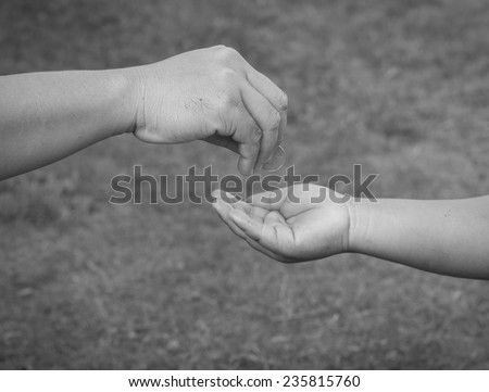 Hand gives coin to a boy