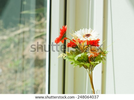 Cloth flower in glass jug on morning shine day.