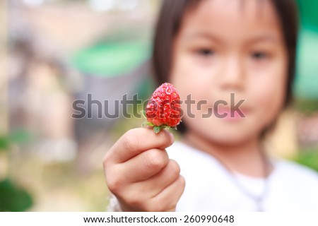 Nong Khai, Thailand - March 16: Unidentified smiling child was show her strawberry at \