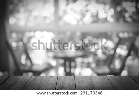 Black and white tone of Wooden table with Coffee shop blur background.