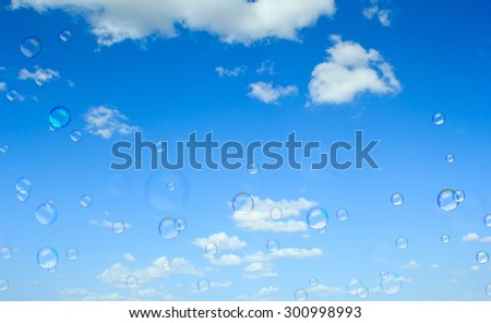 Soap bubbles flying on blue sky background.