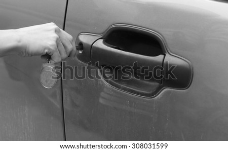 Hand holding car key for unlock the door.