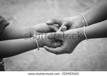 Poor children holding a little boy hands.
