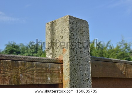 A concrete post holding a fence panel.