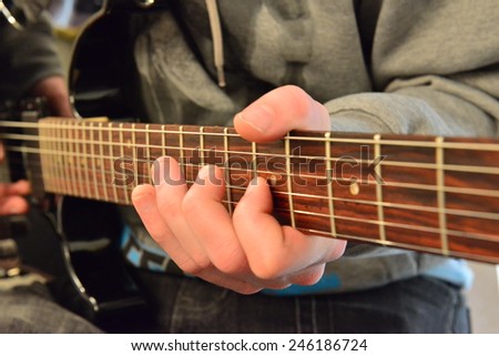 Finger work on the fret board of an electric guitar.