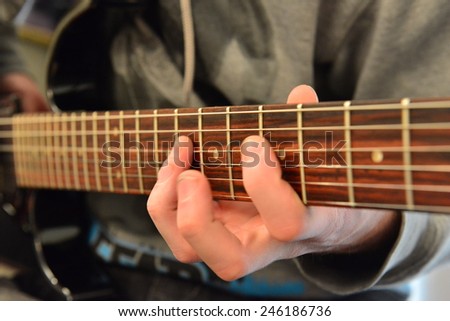 Finger work on the fret board of an electric guitar.