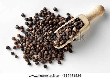 black peppercorns in wooden spoon isolated
