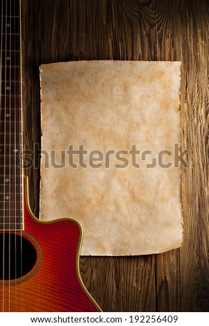 aged paper sheet with country guitar on aged wood background