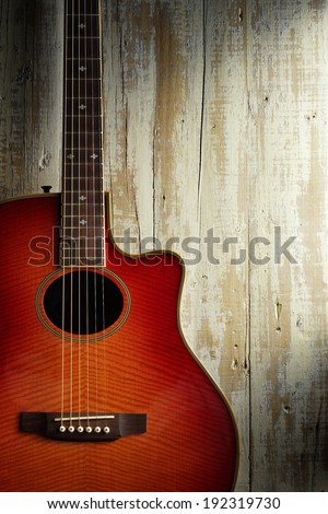 western acoustic guitar on aged light wood background