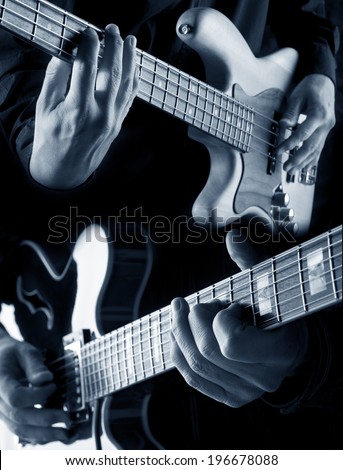 bassist and guitarist playing, blue filtered image