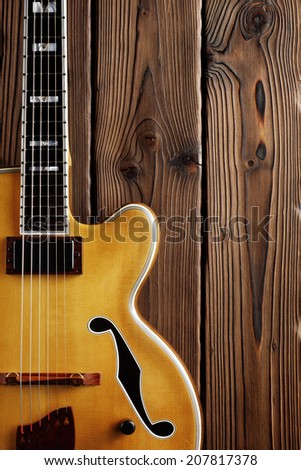 hollow body jazz guitar on aged wood background