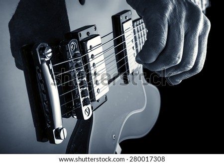 hand of guitarist playing an electric guitar, blue image