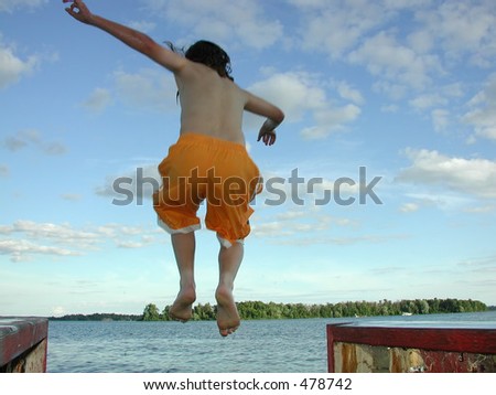 young boy jumping off a dock in the St. Lawrence River