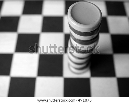 tall stack of checkers on a checkerboard