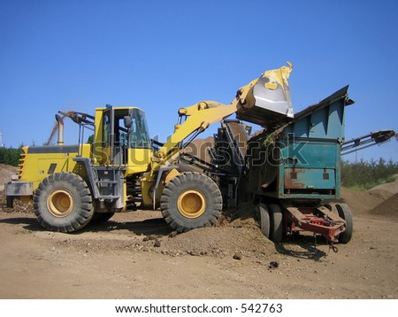 Loader and gravel crusher on site at gravel pit
