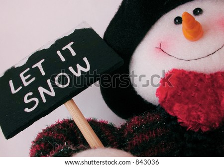 snowman holding sign saying let it snow