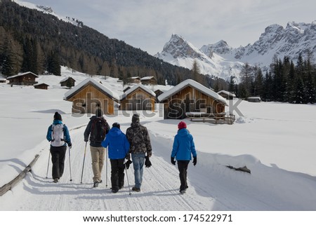 Group  hiking on a snowy trail in val di fassa, in the dolomites