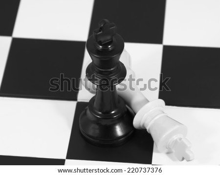 Chess board game in checkmate match : black king beat white king one on chess board background