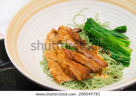 Jade noodle with crispy fried pork chinese hongkong  tradition food closeup on big bowl