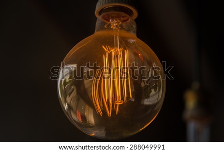 Orange light bulb in dark room of coffee shop closeup