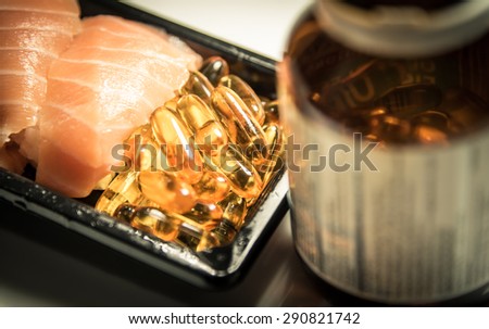Sushi served with piles of fish oil capsules food supplement near brown bottle golden vintage tone