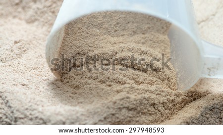 Isolate protein powder chocolate deluxe flavour with scoop macro closeup