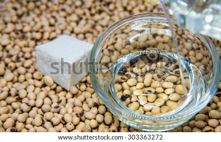 Soybean oil  poured from bottle into the glass bowl focuse on the bowl